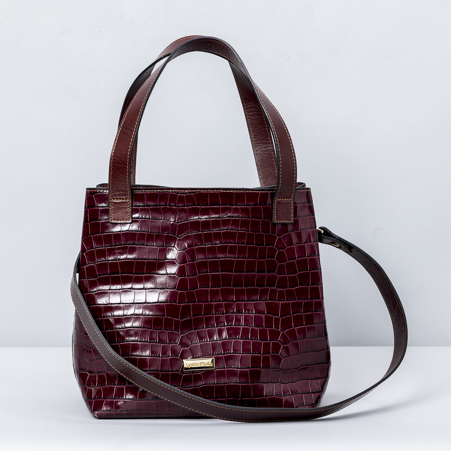 Sac Gabriela en Cuir Façon Croco Bordeaux – Fabriqué à la Main au Portugal Découvrez le sac Gabriela, une pièce unique en cuir façon croco de couleur bordeaux. Fabriqué à la main au Portugal, ce sac combine élégance, sophistication et savoir-faire artisanal. Conçu pour les femmes modernes, ce sac à main se distingue par son cuir haut de gamme et son design intemporel, parfait pour toute occasion. Chaque sac Gabriela est une œuvre d’art exclusive, réalisée par des artisans portugais passionnés. La texture unique du cuir croco et la teinte profonde du bordeaux apportent à ce sac un style raffiné et une touche de luxe. Son design chic et sa fabrication artisanale garantissent une qualité exceptionnelle, tout en étant une pièce durable dans le temps. Grâce à sa forme pratique et élégante, le sac Gabriela se porte aussi bien pour un soirée élégante que pour un look quotidien. Il offre suffisamment de place pour transporter vos essentiels tout en restant compact et léger. Ce sac à main en cuir façon croco est l’accessoire parfait pour compléter votre garde-robe. Caractéristiques principales : Cuir façon croco de haute qualité Couleur bordeaux élégante et tendance Fabrication artisanale au Portugal Pièce unique et exclusive Design moderne et intemporel Idéal pour les occasions spéciales ou un usage quotidien Le sac Gabriela en cuir façon croco bordeaux est une véritable déclaration de style et de raffinement. Ajoutez-le à votre collection pour apporter une touche de luxe à vos tenues